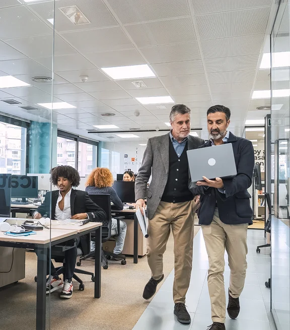 Two colleagues reviewing workplace operations on a laptop in an office