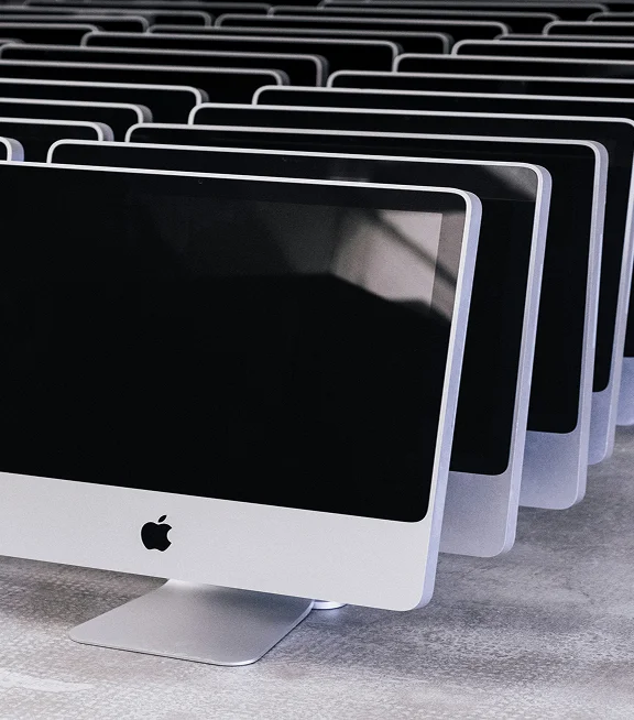 A row of iMac computers set up in a modern office
