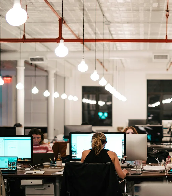 A busy modern open-plan office with employees at workstations
