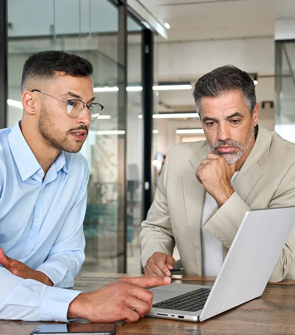 Two colleagues reviewing workplace data together on a laptop