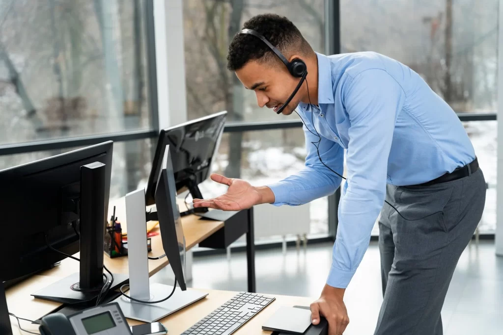 A man talking on call while looking at computer screen