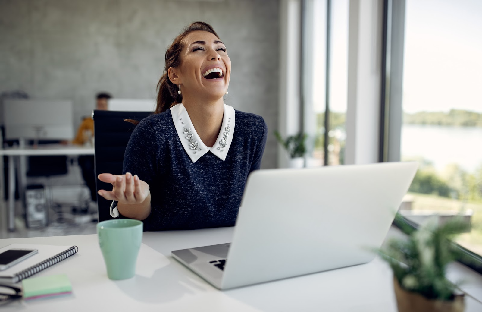 Woman laughing and using a laptop